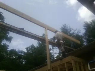 Carpenter setting a ridge beam over a new addition frame — Ice Dam Removal by Roofing Brothers in Hewitt