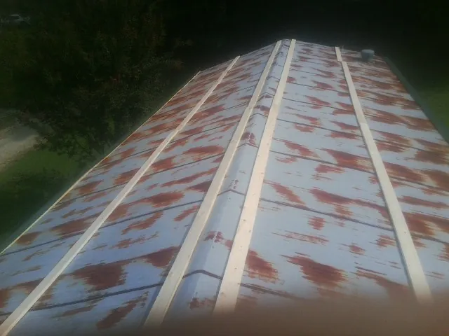 Rusted metal roof panels with new wood purlins before replacement — Storm Damage Roof Repair in Hewitt by Roofing Brothers