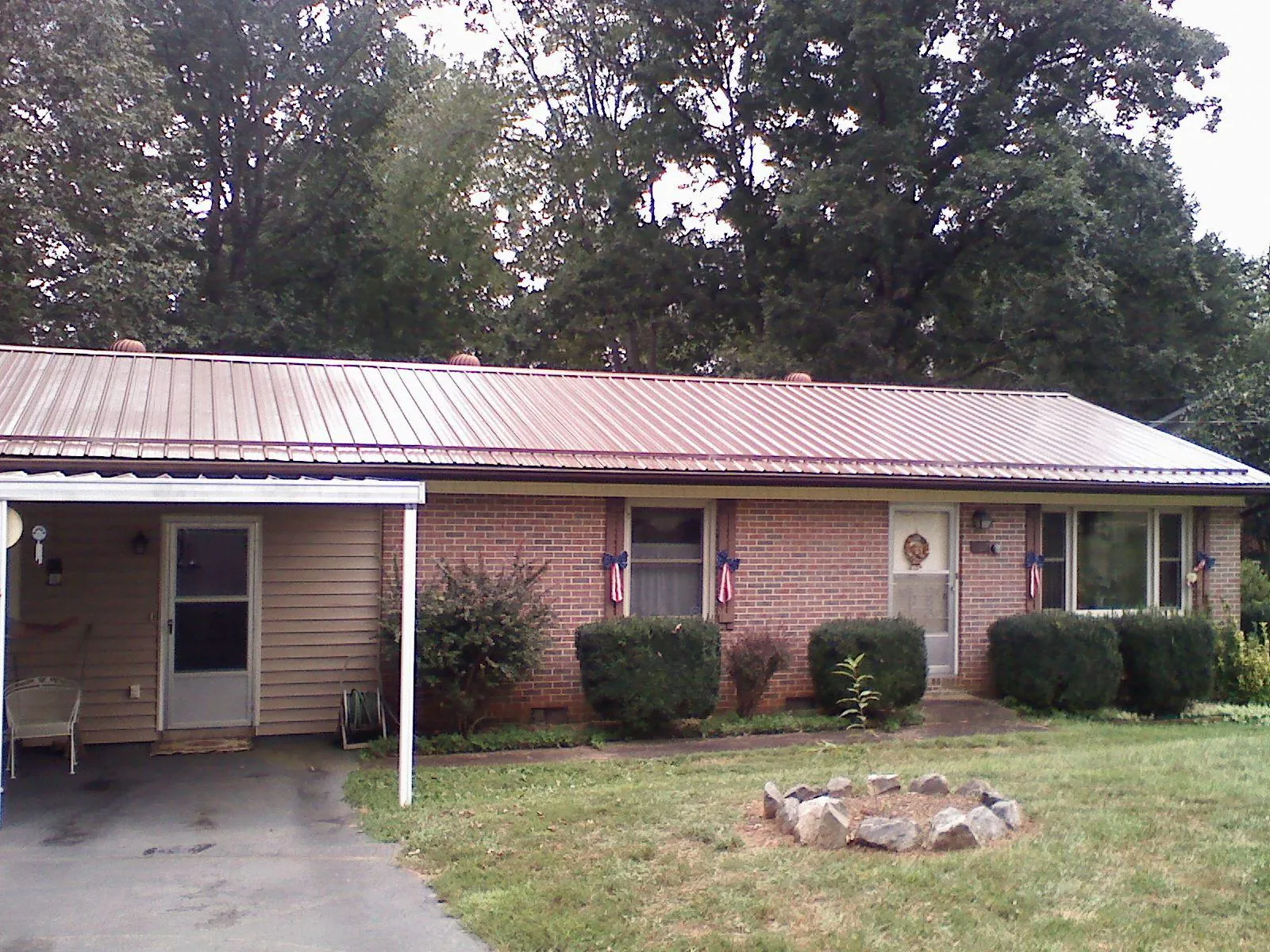 Bronze metal roof and carport on a brick ranch home — Roof Repair work by our crew in Hewitt